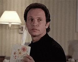 Movie gif. Billy Crystal as Harry in When Harry Met Sally blinks and calmly offers a box of tissues.