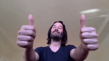Celebrity gif. Keanu Reeves looks at us with a proud smile and two big thumbs up. 