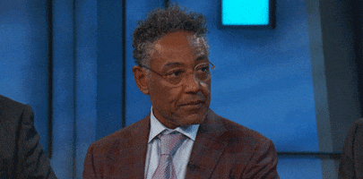Celebrity gif. Giancarlo Esposito looks over at someone with a subtle annoyed look. He gulps and looks away slowly.