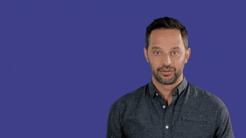 Celebrity gif. Nick Kroll against a purple background with a half smile, puts out his hand, and text appears, "happy birthday. Instead of a real gift I got you this Gif."