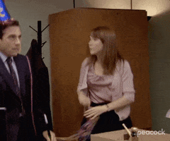 The Office gif. Steve Carell as Michael Scott wears a birthday hat and Ellie Kemper as Erin Hannon holds streamers in her hand. Both are dancing in a festive manner, celebrating someone's birthday in an awkward way. 