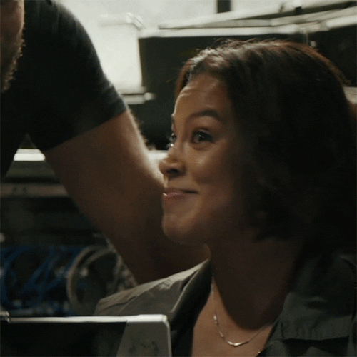 TV gif. Toni Trucks as Lisa on Seal team turns away from someone with a huge excited smile on her face. Text, "Awesome."