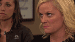 Parks and Recreation gif. Amy Poehler as Leslie purses her lips as her eyes dart around, in a seething rage.