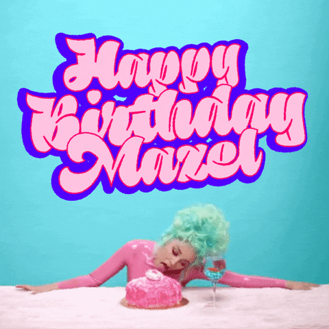 Celebrity gif. Doja Cat sporting a bright aqua beehive, licks a pink cake on a table in front of her, a goldfish in a wineglass beside, big graffiti-style letters bounce and bob above her, reading "Happy birthday, mazel."