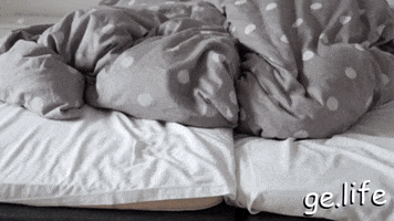Intimate Couple Touching Feet In Bed GIF