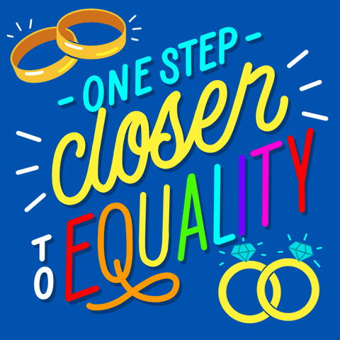 Text gif. Stylized letters in cyan yellow and rainbow on a cobalt background surrounded by a set of men's wedding bands, a set of women's engagement rings, and action lines. Text, One step closer to equality.