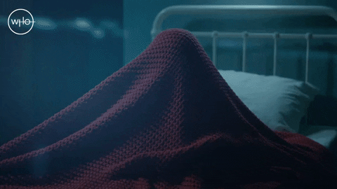 Person quickly pulling a blanket back, peering intensely under the bed