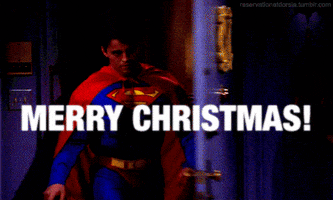 Friends gif. Matt LeBlanc as Joey bursts through the apartment door wearing a Superman costume as he says with a rascally smile, "Merry Christmas!"
