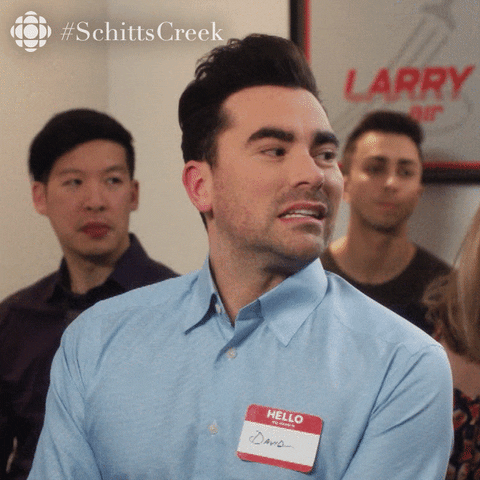 Schitt's Creek gif. Dan Levy as David sits in a room during a meeting, wearing a nametag. He says, "Ooh, that's true."