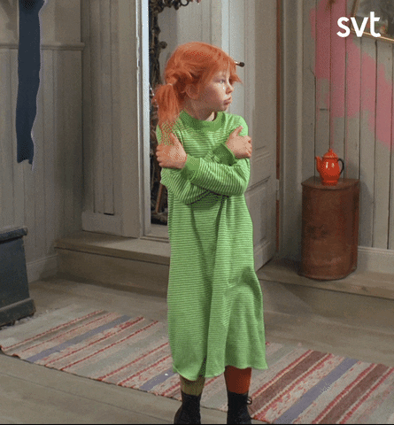TV gif. Inger Nilsson as Pippi Longstocking glances around looking cold, as her knees tremble and arms wave to wrap herself.