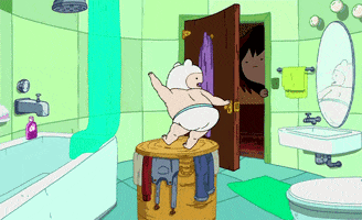 Cartoon gif. As a baby, Finn the Human from Adventure Time dances happily in his underwear on top of a hamper in the bathroom as his mother looks on.
