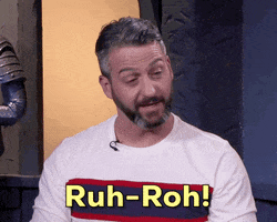 Video gif. Jeff Cannata from The Dungeon Run looks nervous but smiles while saying "ruh-roh!"