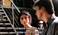 TV gif. Morena Baccarin as Inara and Nathan Fillion as Malcolm in Firefly, intently look at each other. Text reads, "Someone needs to keep Kaylee out of trouble."