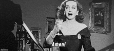 Movie gif. Bette Davis as Margo Channing in All About Eve raises her champagne with an "amen!"