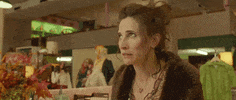 Movie gif. Michaela Watkins as Dolores Jr in "Antiquities" rolls her eyes and shakes her head, frowning, before turning away.