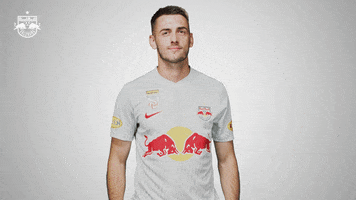 Sports gif. Aleksa Terzic of FC Red Bull Salzburg wearing a jersey shakes his fists in intense celebration, giving a friendly yell in front of a white background.