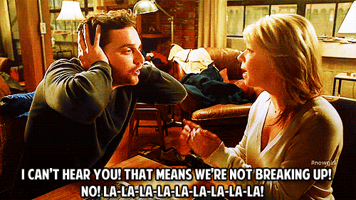 GIF from a scene in New Girl where a character named Nick is being broken up with by his girlfriend, Carolyn. He has his hands over his ears and he's saying, "I can't hear you! That means we're not breaking up! No! La-la-la-la-la-la-la-la!