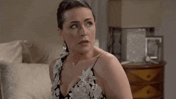 TV gif. Rena Sofer as Quinn Fuller on The Bold and The Beautiful. She's sitting on a bed and looks exasperated as she sighs, turns away, opens her palms, and looks up while saying, "What?!"