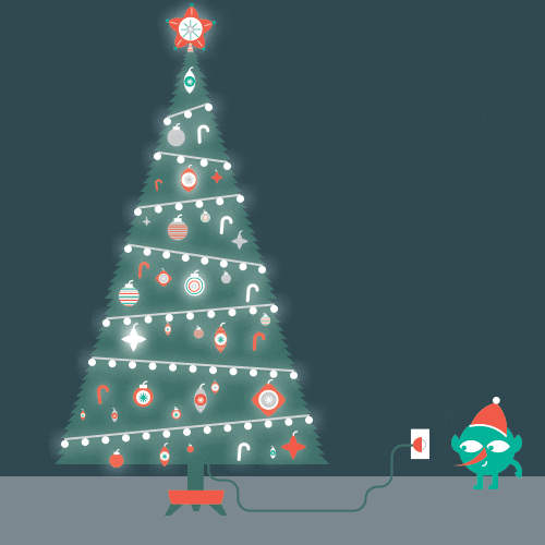 Digital art gif. Tiny green elf in a Santa hat plugs in an enormous and beautifully decorated sparkling Christmas tree.
