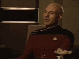 TV gif. Patrick Stewart as Picard in Star Trek shakes his head slightly, looking proud and smiling as he slow-claps.