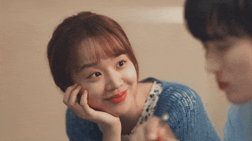 TV gif. Shin Hye Sun as Kang Da Jeong in See you in My 19th Life rests her chin on her palm and smiles sweetly while looking adoringly at Ahn Bo-hyun as Moon Seo-ha who is eating in the foreground.