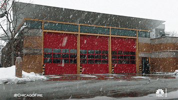 TV gif. Scene from Chicago fire. Snow falls around a fire station.
