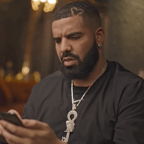 Celebrity gif. Popstar Drake stares at his smartphone and shakes his head in disbelief. He can't believe what he’s looking at and can only react to it by saying, “wow.”