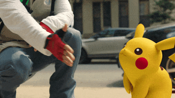 Pokémon gif. Pikachu jumps forward and lands an enthusiastic high five on the hand of a person squatting beside him.