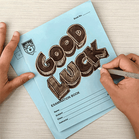 Video gif. On a college examination blue book, a person artistically writes the words, “Good Luck.”