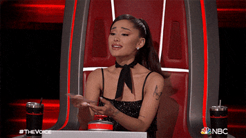 Reality TV gif. Ariana Grande is a judge on The Voice and she puts her hands to her chest and has a pleading expression on, appealing to the contestant.