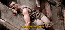 TV gif. Ray Stevenson as Titus Pullo from Rome asleep on an outdoor staircase with his head resting on his arm. Text, "Here I am. Drunk again."