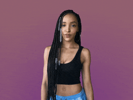 Celebrity gif. Tinashe rolls her eyes and holds her hands up to make a big W as she says, “Whatever.”