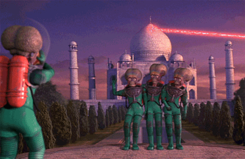 An animated gif clip from the movie Mars Attacks with three martians standing in a row to take a photo in front of the Taj Mahal just as it is being blown up