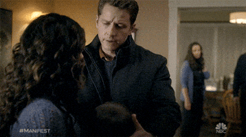 TV gif. Josh Dallas as Ben in Manifest pulls a woman and a boy in close for a warm and consoling embrace. 