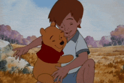 Cartoon gif. Christopher Robin and Winnie the Pooh embrace each other in a warm hug.
