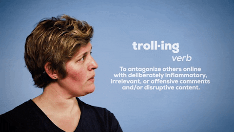 Women looking towards screen with definition of trolling which describes it has very - To antagonize others online with deliberately inflammatory, irrelevant, or offensive comments and/or disruptive content.