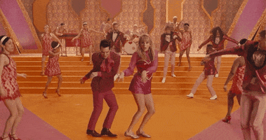 Music video gif. From Taylor Swift's Me, Taylor and Brendon Urie dance The Twist.