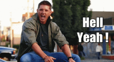 Movie gif. Jensen Ackles as Dean Winchester in Supernatural excitedly shimmies his shoulders. Text, "Hell yeah!"
