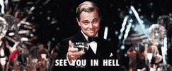 Movie gif. Wearing a tuxedo, Leonardo DiCaprio toasts to us with a glass of white wine and a complicated smile. A large celebration with fireworks and a ferris wheel goes on behind him. Text, "See you in hell."