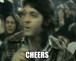 Celebrity gif. Young Paul McCartney sips a cup of beer and smiles. Text, "Cheers."