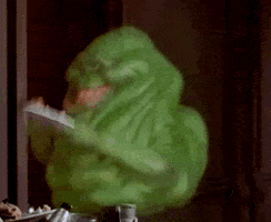 Movie gif. Slimer, the green blob ghost from Ghostbusters shoves a plate of food to his wide mouth as his thick tongue slaps it down. 