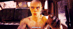 Movie gif. Nicholas Hoult as Nux in Mad Max Fury Road driving a vehicle. Text, "witness me."