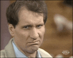 TV gif. Ed O'Neill as Al Bundy from Married with Children gives us a few meek shrugs as if to say "oh well, that's life", then scrunches his face with confusion and disgust.