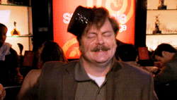 Parks and Recreation gif. In a crowded bar with a sign that reads "snakehole lounge", Nick Offerman as Ron Swanson does a drunken dance with his eyes closed while a small black hat sits off-kilter on his head.