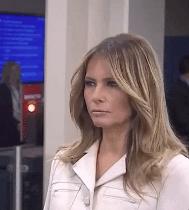 Celebrity gif. Melania Trump turns her head and gazes with half open eyes. Her expression is unclear as she could be angry or confused or just trying to pose for a picture.