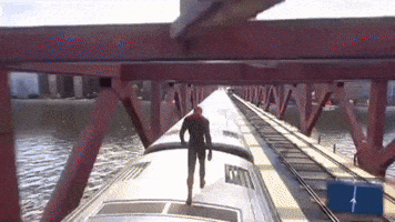 Digital art gif. Spiderman walks with his head hung low on top of a fast-moving train that's going the opposite direction underneath a bridge. 