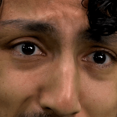 Video gif. Closeup of a man's sad eyes as they well up with cartoon tears that drip down his cheeks.