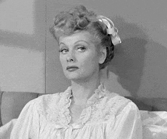 TV gif. Closeup of Lucille Ball as Lucy in I Love Lucy wearing pajamas and sticking her tongue out towards us with her eyebrows raised.