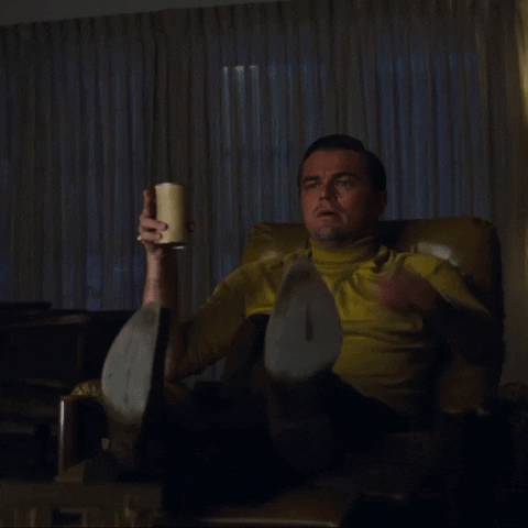 Meme gif. The "Pointing Rick Dalton" meme. In a scene from Once Upon a Time in Hollywood, Leonardo DiCaprio as Rick Dalton sits up from an armchair and points intently out of frame.