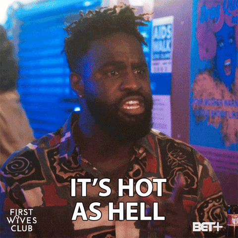 TV gif. Terrence Terrell as Wesley from First Wives Club. He's sitting in a dark bar and a sheen of sweat is on his forehead as he informs his friend, "It's hot as hell."